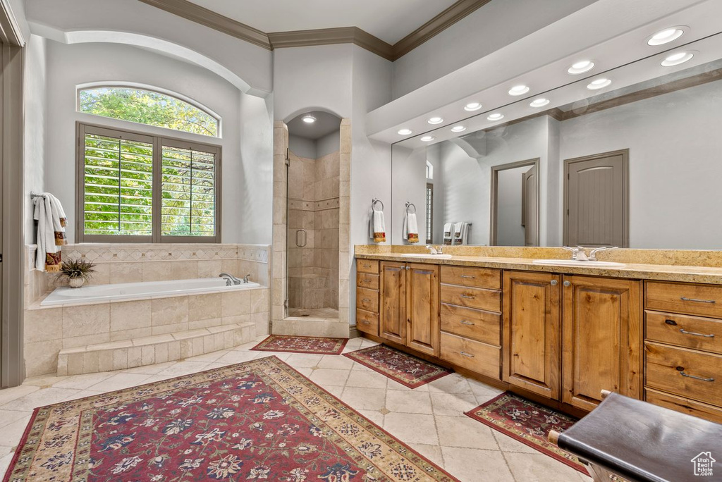 Full bath with tile patterned floors, crown molding, recessed lighting, a bath, and a stall shower
