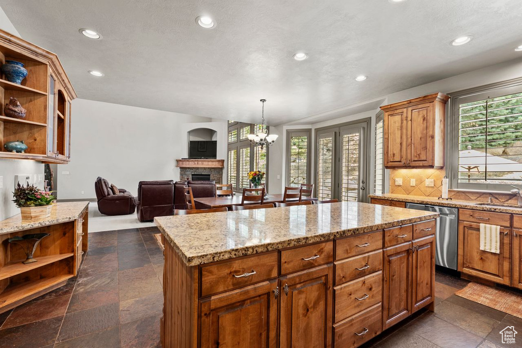 Kitchen with open shelves, a fireplace, a kitchen island, recessed lighting, and plenty of natural light