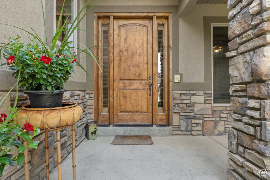 Entrance to property with stone siding and stucco siding