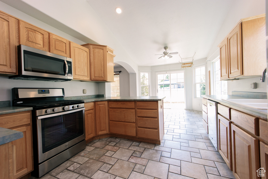 Kitchen with appliances with stainless steel finishes, ceiling fan, arched walkways, a peninsula, and recessed lighting