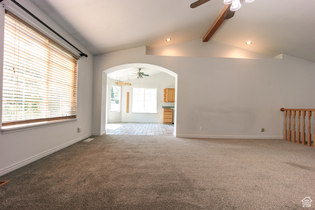 Empty room with a ceiling fan, light carpet, arched walkways, and recessed lighting