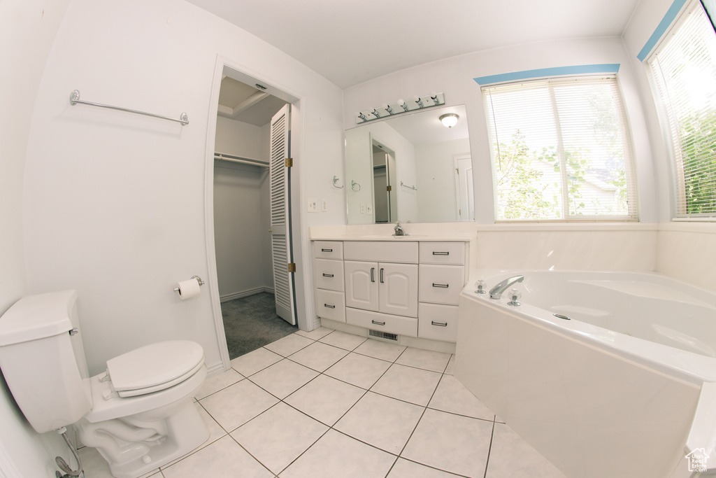 Bathroom featuring vanity, a garden tub, and tile patterned floors
