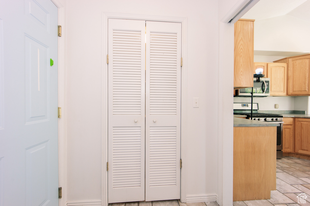 Kitchen with stainless steel appliances, light brown cabinets, and light countertops
