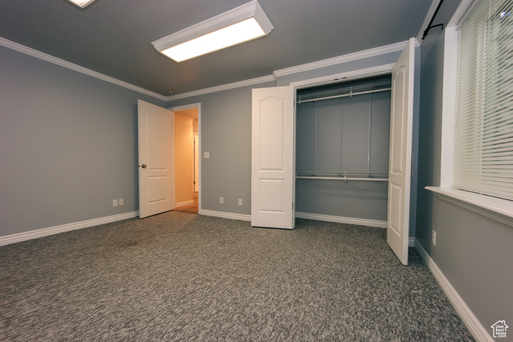 Unfurnished bedroom featuring carpet floors, a closet, and crown molding