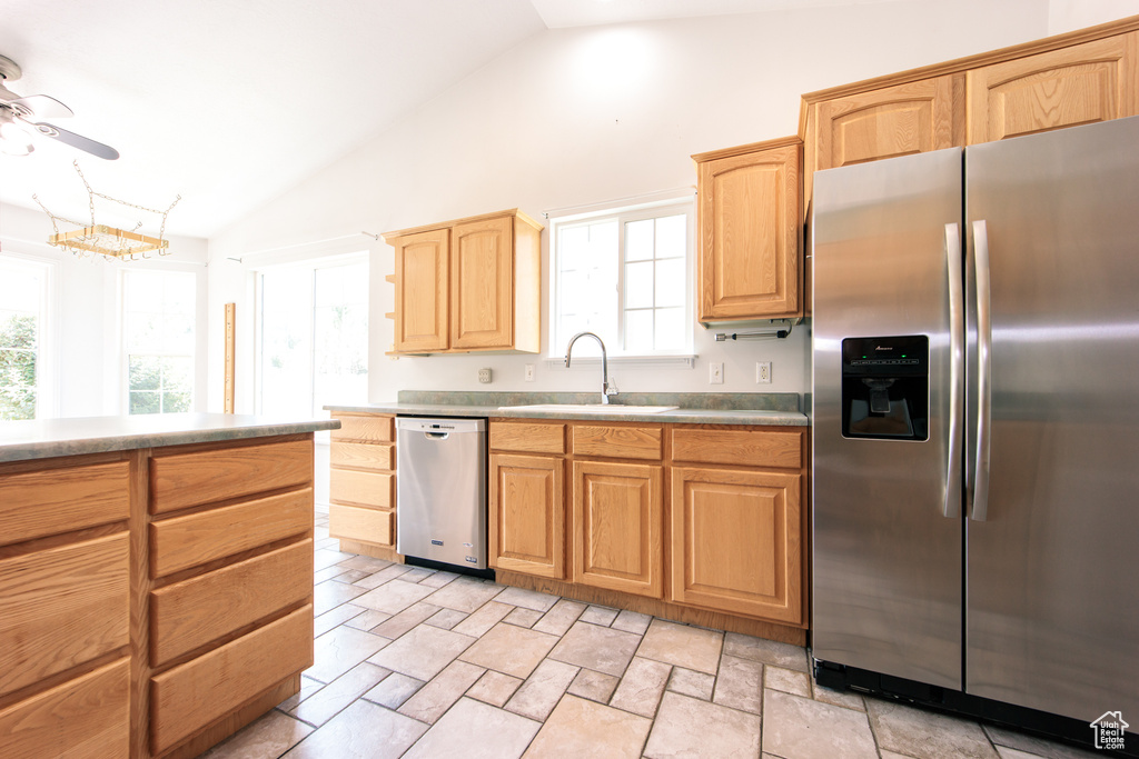 Kitchen with appliances with stainless steel finishes, a ceiling fan, plenty of natural light, and high vaulted ceiling