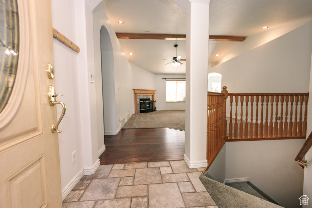 Foyer featuring ceiling fan, a tile fireplace, arched walkways, stone tile flooring, and recessed lighting