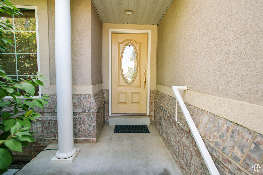 View of exterior entry featuring stucco siding and stone siding