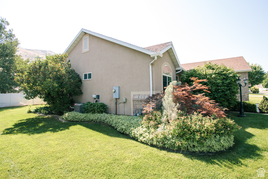 View of side of property featuring stucco siding and a central AC unit