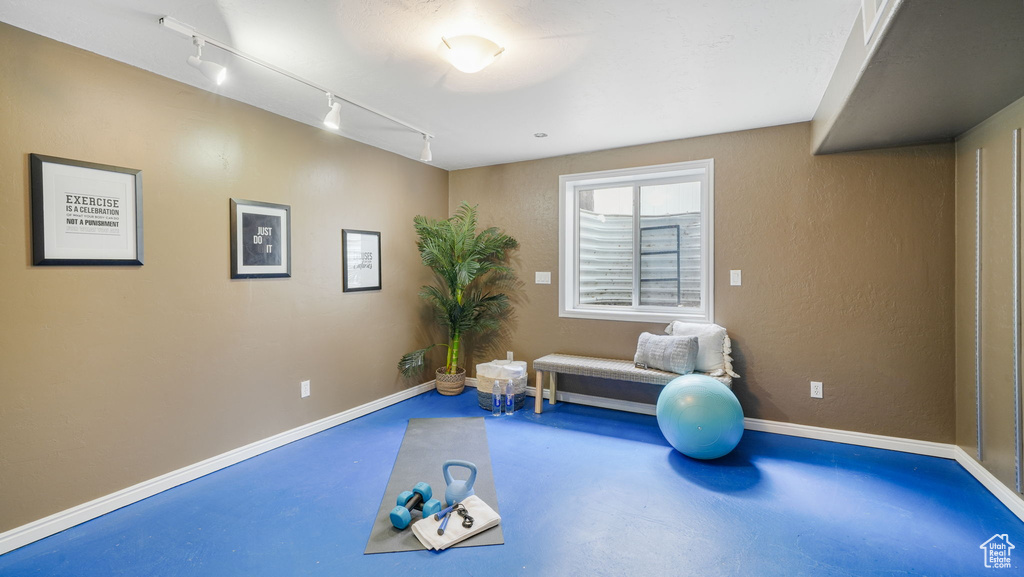 Workout area featuring track lighting and baseboards