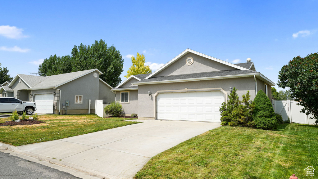 Single story home with stucco siding, a garage, and concrete driveway