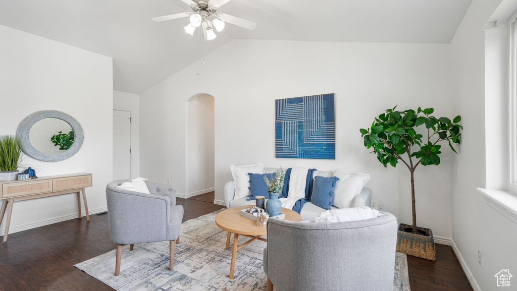 Living room with arched walkways, vaulted ceiling, wood finished floors, and ceiling fan