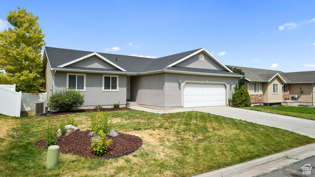 Ranch-style house with stucco siding, an attached garage, and driveway