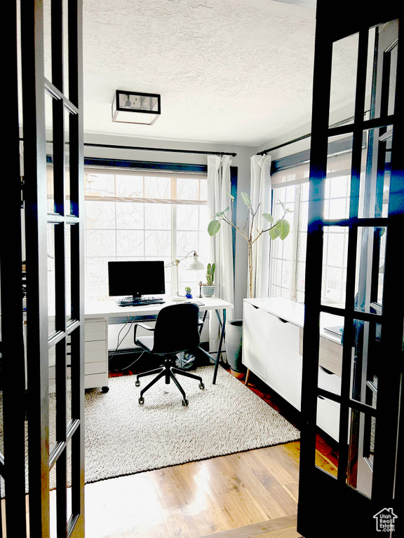 Home office featuring wood finished floors and a textured ceiling
