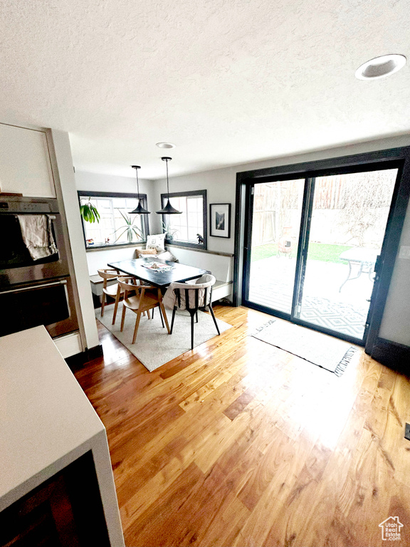 Dining area with a textured ceiling and wood finished floors