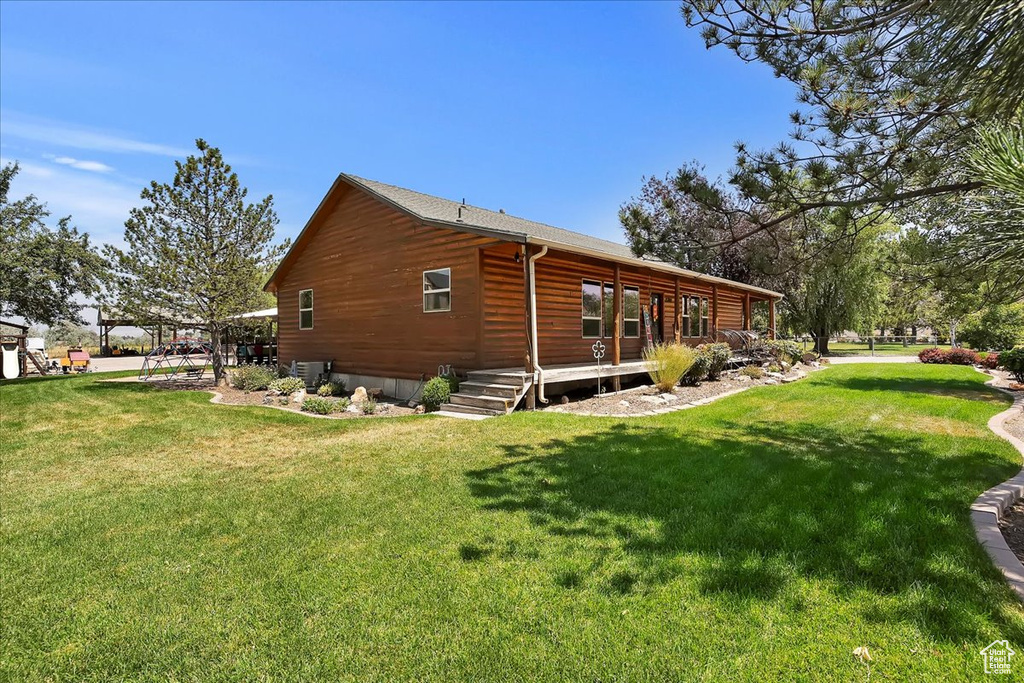 View of side of home featuring a yard