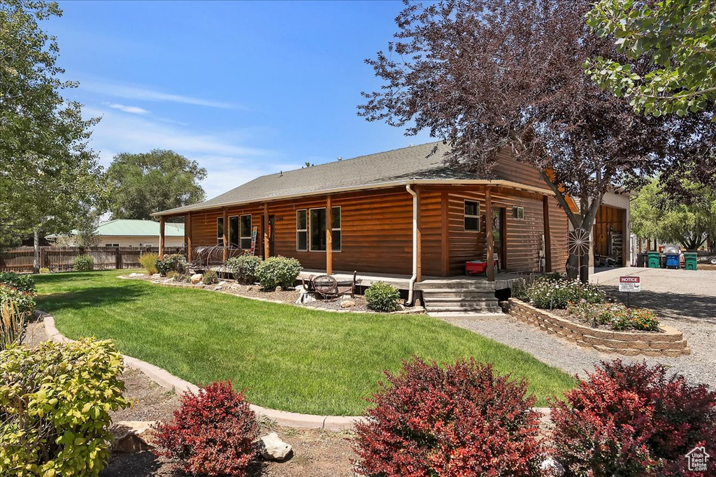 Back of property with covered porch and a shingled roof