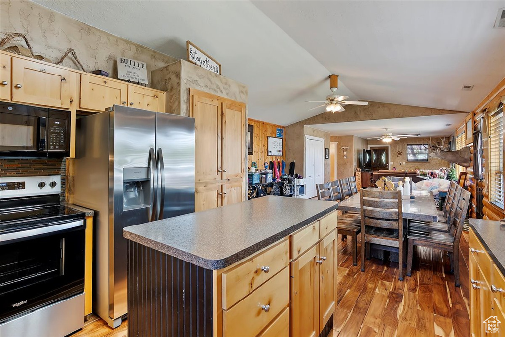 Kitchen featuring appliances with stainless steel finishes, light wood-style flooring, ceiling fan, vaulted ceiling, and light brown cabinets