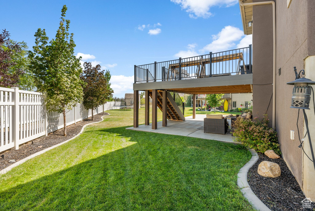 Fenced backyard featuring a patio, a deck, and stairway