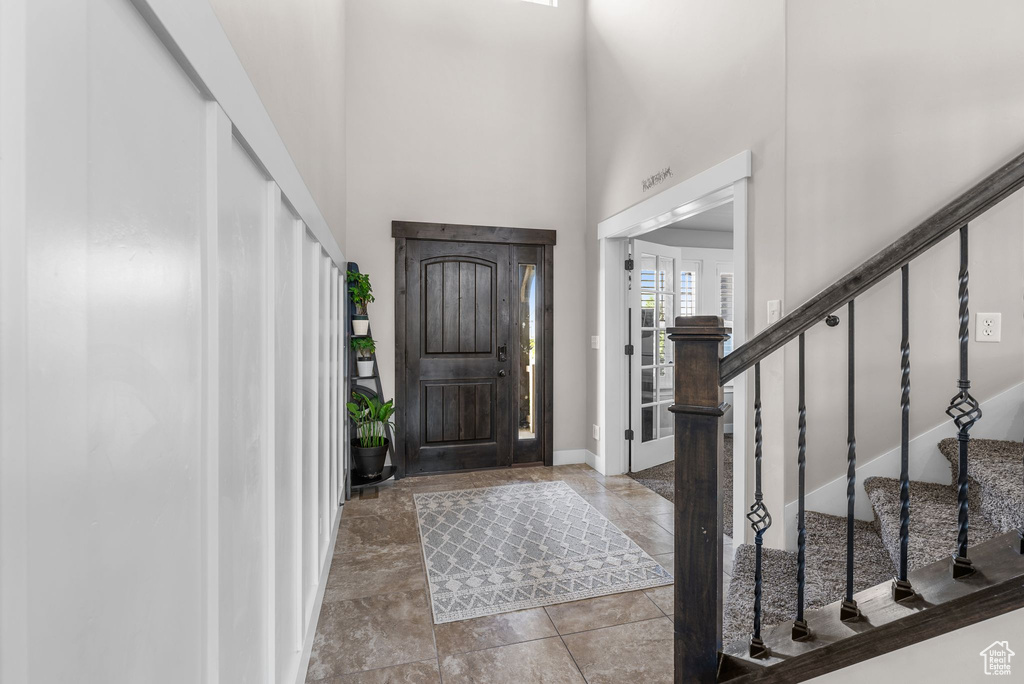 Foyer entrance featuring a towering ceiling and stairway