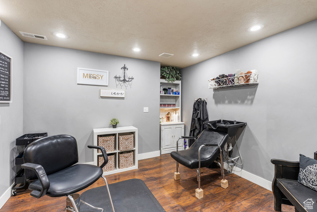 Living area with dark wood finished floors, recessed lighting, and a desk
