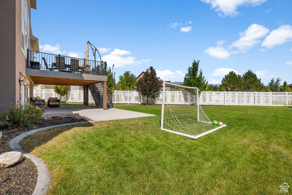 View of yard featuring stairs, a patio, an area for sports, and a deck