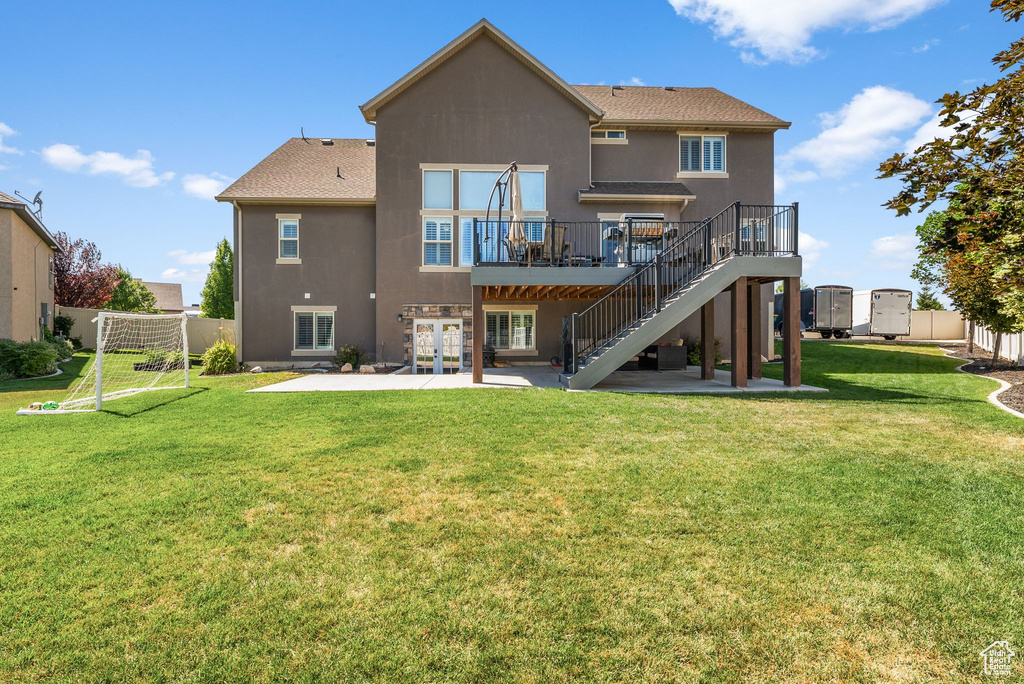 Rear view of property featuring a patio, french doors, stucco siding, stairs, and a wooden deck