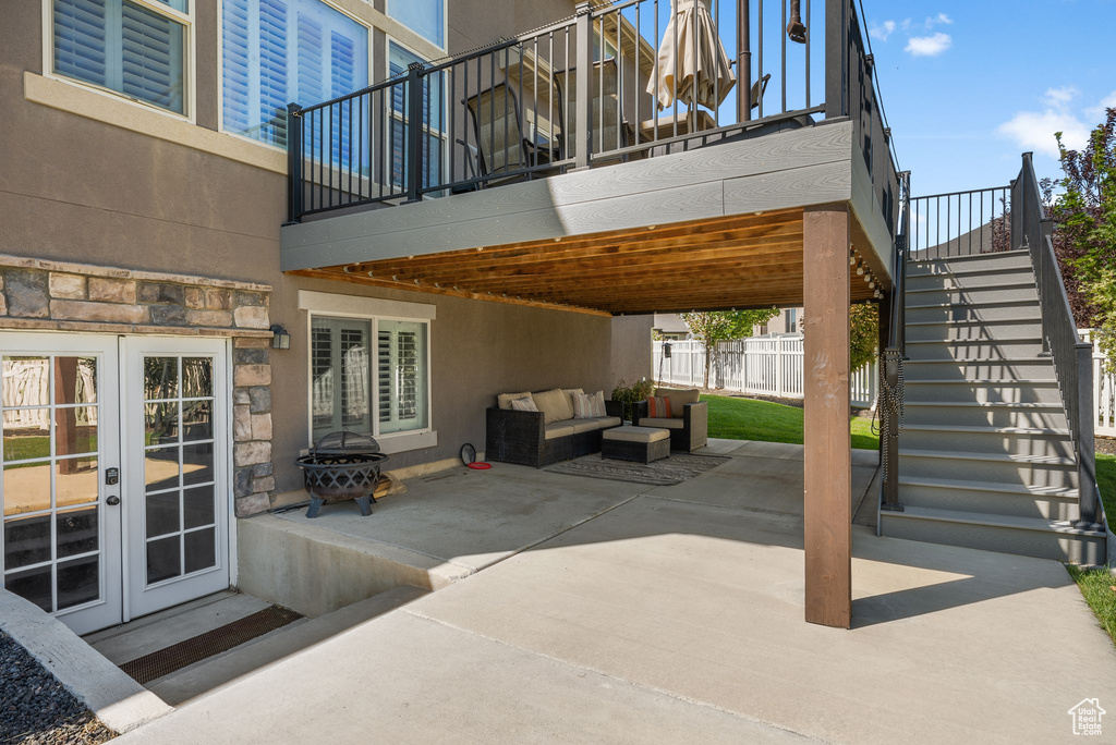 View of patio featuring french doors, stairs, and an outdoor living space with a fire pit