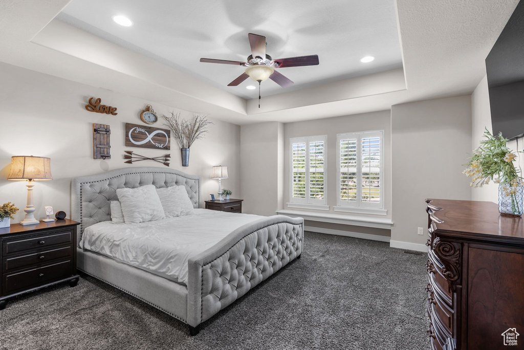 Bedroom featuring a tray ceiling, dark colored carpet, recessed lighting, and ceiling fan