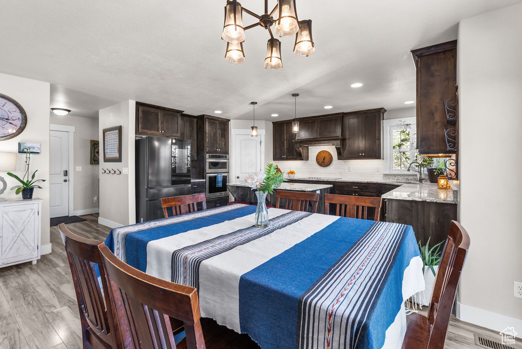 Dining area with a chandelier, light wood finished floors, and recessed lighting