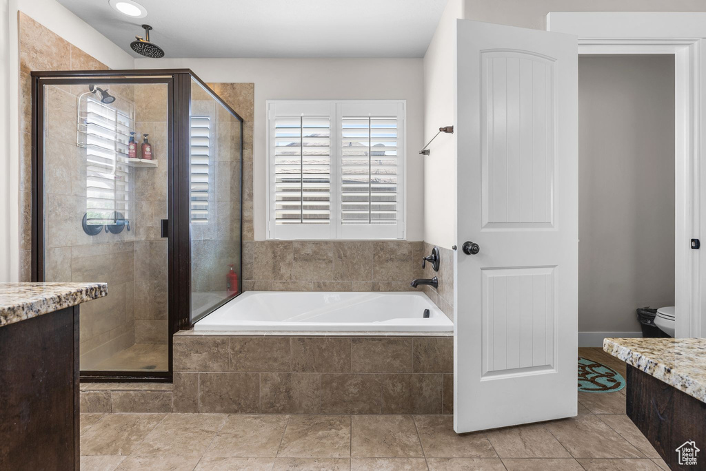 Full bath featuring a stall shower, a bath, and vanity