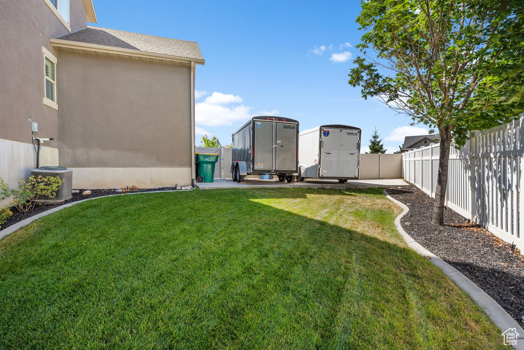 Fenced backyard featuring a shed