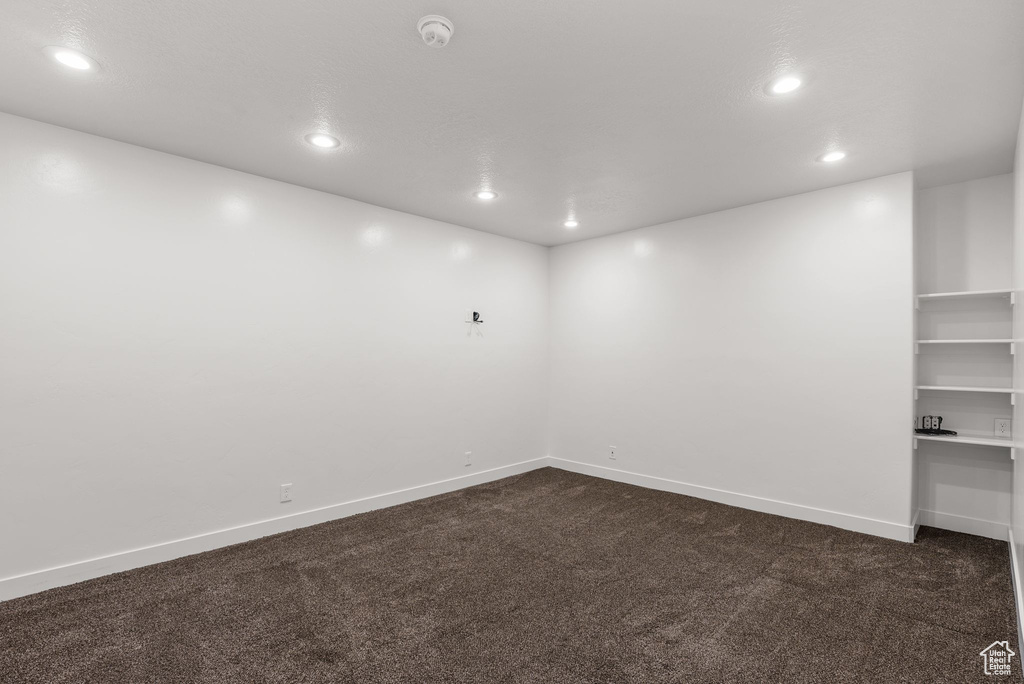 Spare room with dark colored carpet and recessed lighting