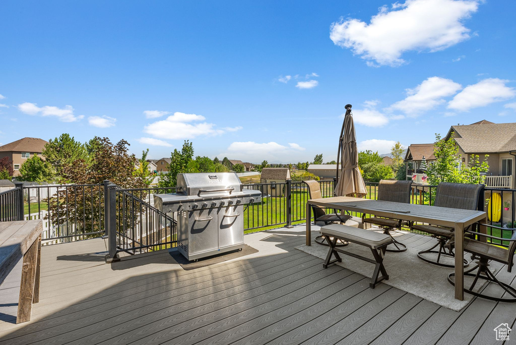 Deck with area for grilling, a residential view, and outdoor dining area