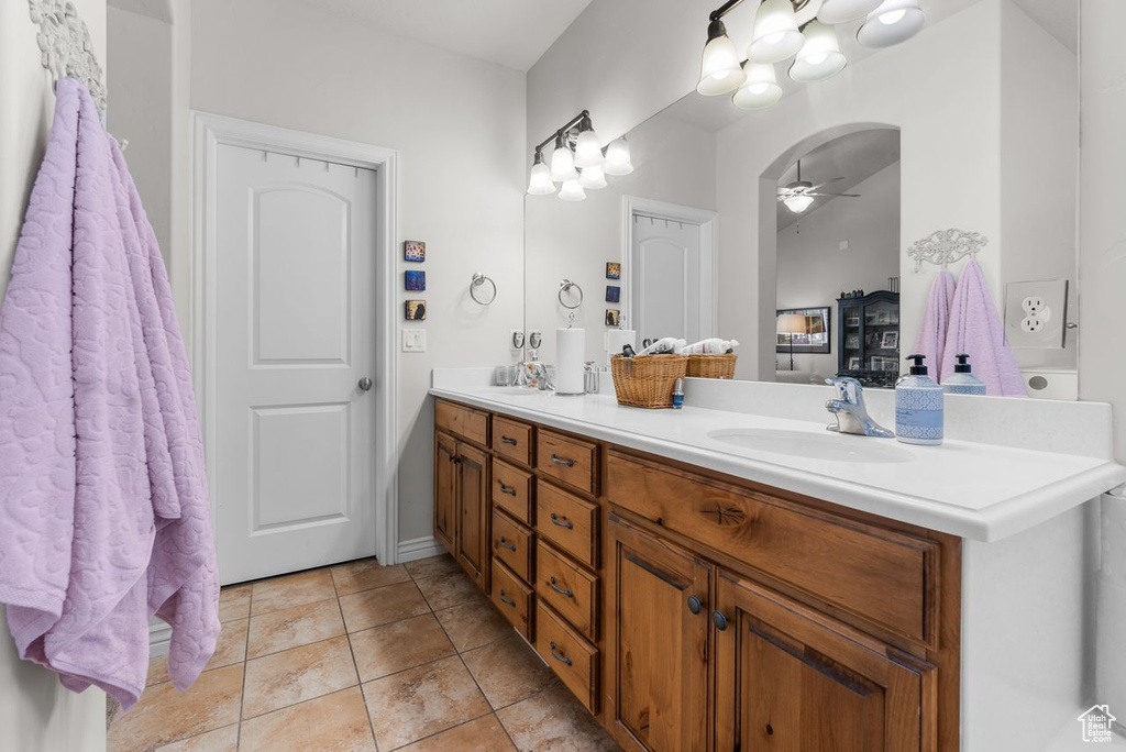Bathroom with double vanity, ceiling fan, tile patterned flooring, and connected bathroom