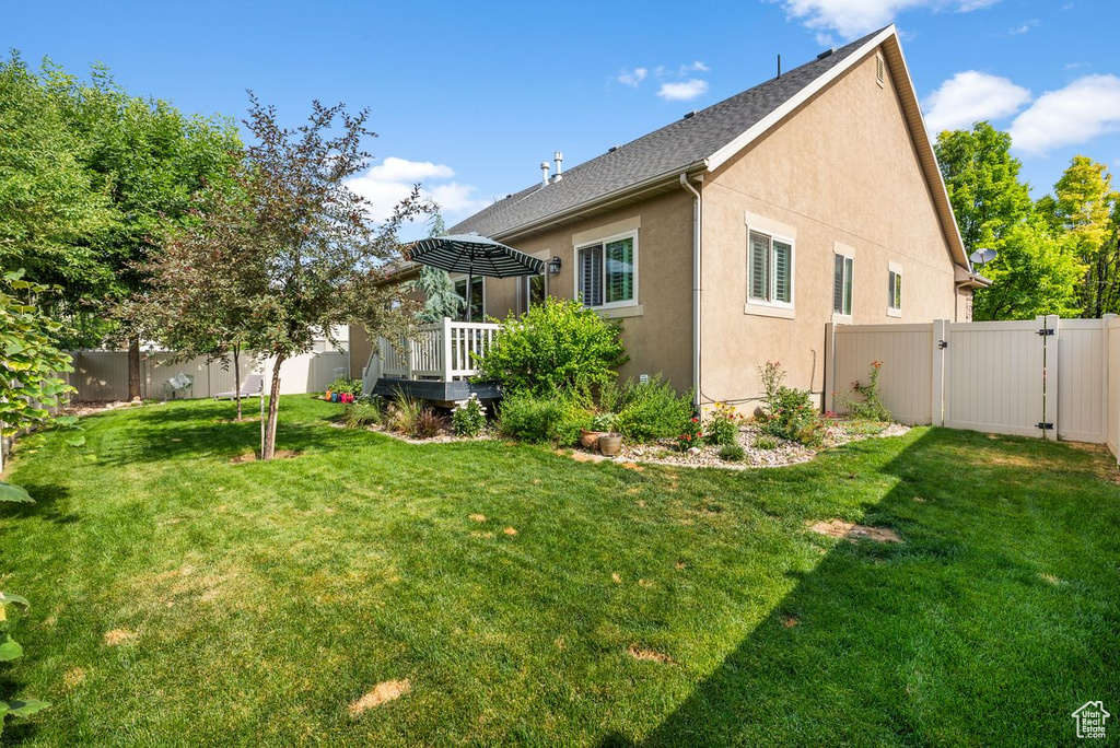 View of home's exterior with a gate, a fenced backyard, stucco siding, and a deck