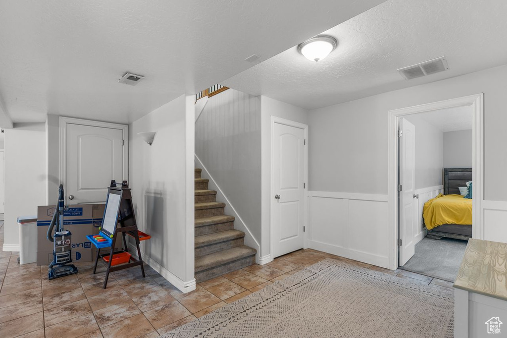 Stairs featuring a textured ceiling