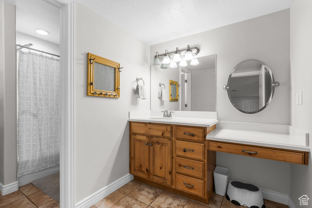 Full bathroom with vanity, tile patterned floors, and a shower with curtain