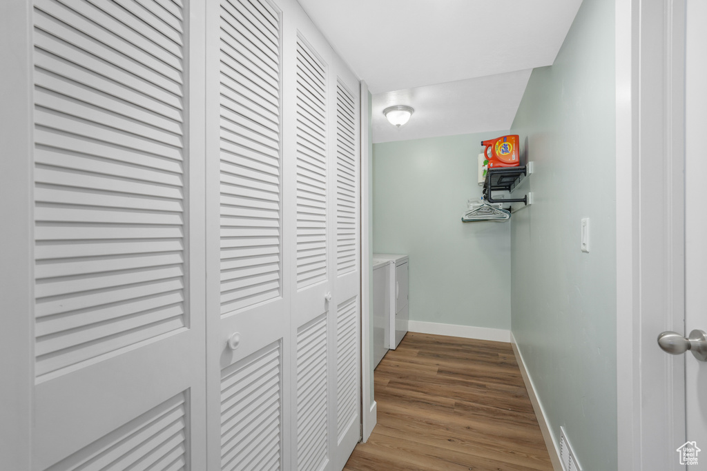 Hallway with independent washer and dryer and wood finished floors