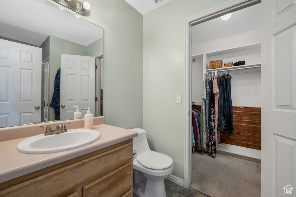 Full bath with vanity, a walk in closet, and a shower
