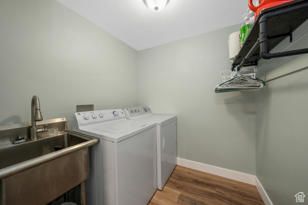 Laundry room with washer and dryer and wood finished floors