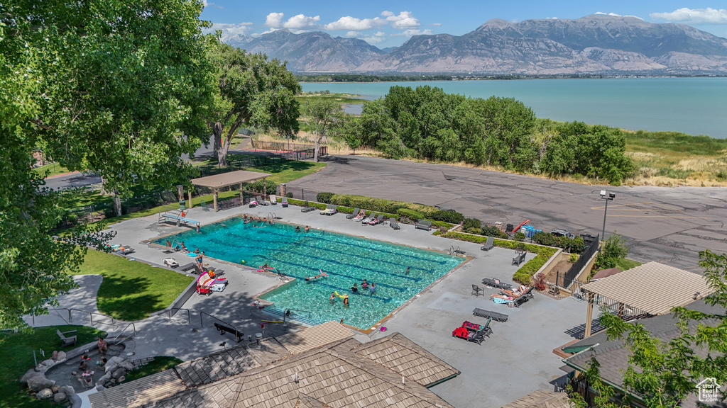 Community pool featuring a water and mountain view and a patio area