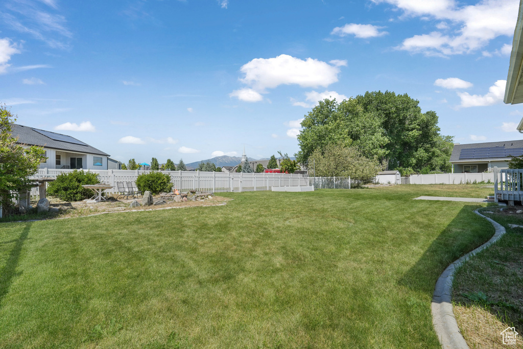 Fenced backyard featuring a storage unit and a mountain view
