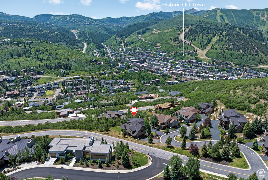 Aerial overview of property's location with a mountainous background and nearby suburban area