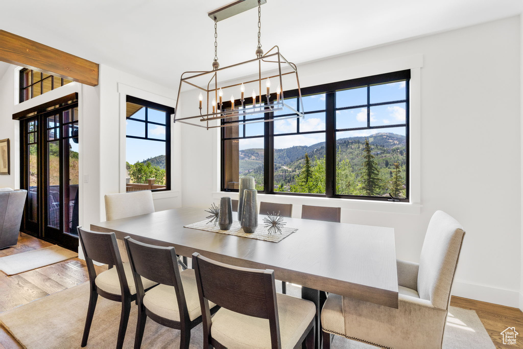 Dining room with wood finished floors and a chandelier
