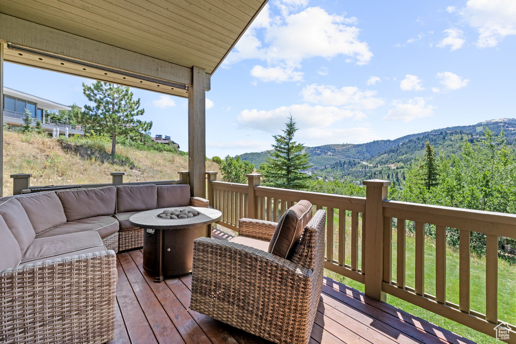 Wooden terrace featuring an outdoor living space with a fire pit and a mountain view