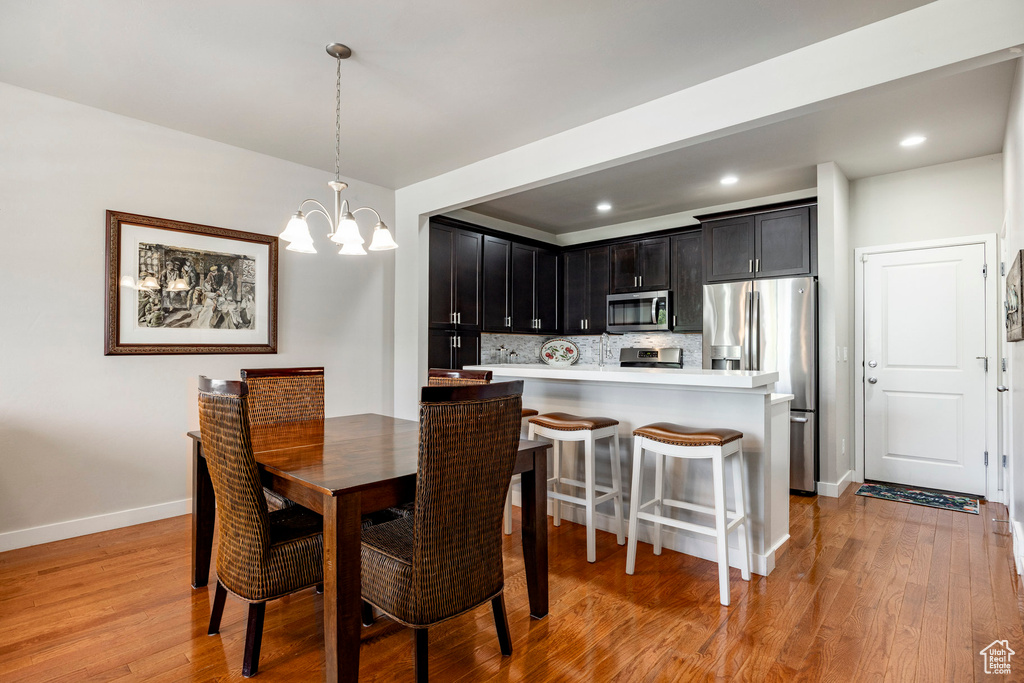 Dining room featuring a chandelier, light wood-style flooring, and recessed lighting