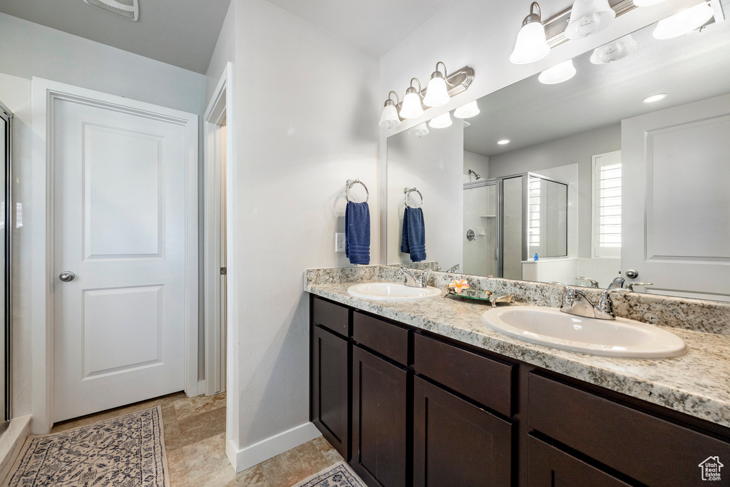 Bathroom featuring a shower stall and double vanity