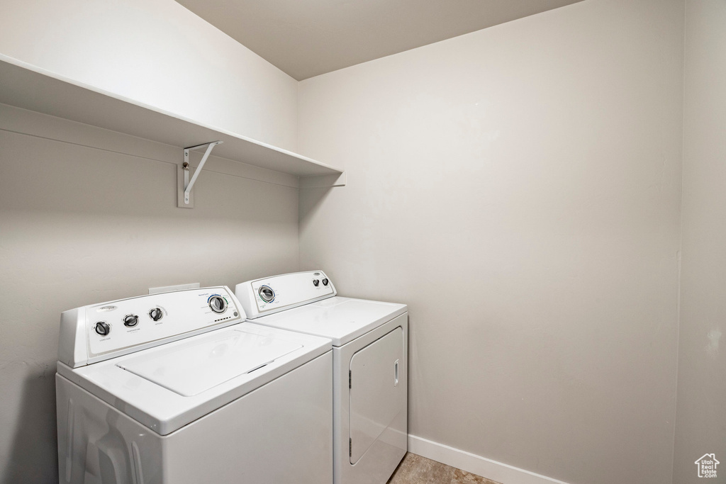 Laundry room with washer and clothes dryer and baseboards