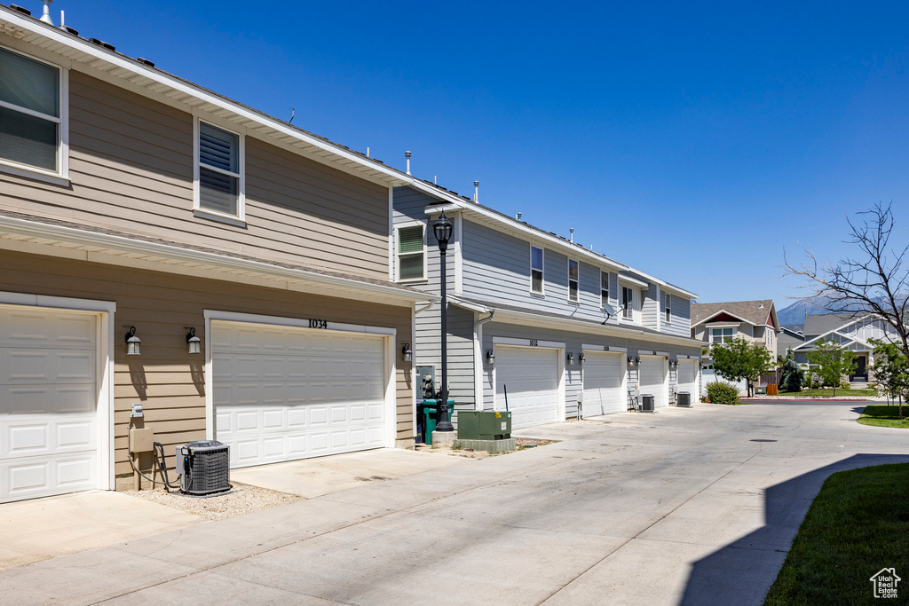 Rear view of property featuring driveway and an attached garage