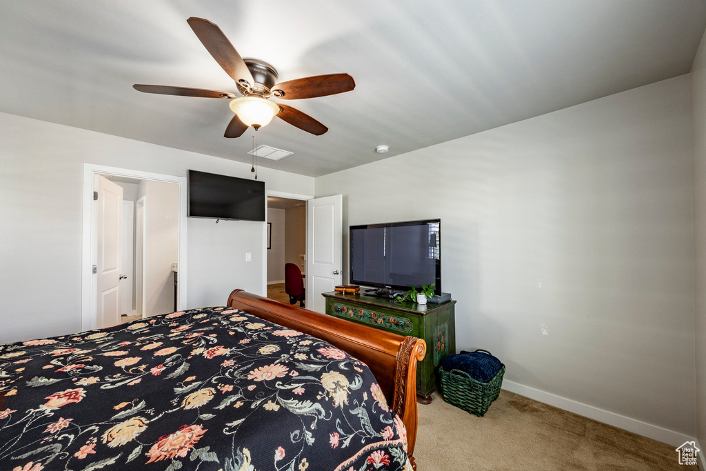 Carpeted bedroom with baseboards and a ceiling fan